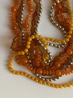 Early vintage Miriam Haskell four strand beaded necklace with matching clip-on earrings. Made up of orange and amber colored glass beads and silver faux baroque pearl beads. The amber color glass beads have cut lines to make the beads look like leaves. Necklace measures 28" in length and the earrings are approximately 1 1/2". Very good previously owned vintage condition. Please view all photos as part of this description. I am always happy to respond to questions. This item will ship USPS. Retro Orange Jewelry For Party, Vintage Orange Beaded Necklaces For Formal Occasions, Vintage Amber Jewelry With Large Beads, Orange Multi-strand Polished Beads Jewelry, Vintage Amber Beaded Necklaces, Polished Vintage Beads, Orange Round Beads Jewelry For Party, Orange Round Beads Party Jewelry, Vintage Orange Necklace With Colorful Beads