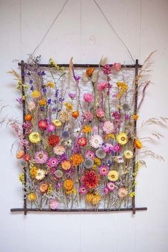 a bunch of flowers are hanging on a wall