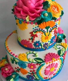 a three layer cake decorated with colorful flowers