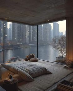 a bedroom with a large window overlooking the water