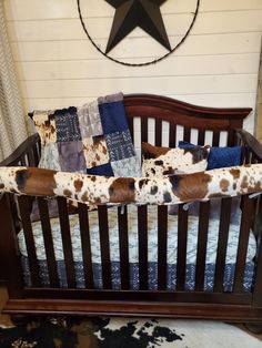 a brown and white cow print crib bedding in a room with a star on the wall