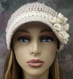 a mannequin head wearing a white crochet hat with flowers on it