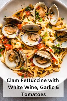 clam fettuccine with white wine, garlic and tomatoes in a bowl