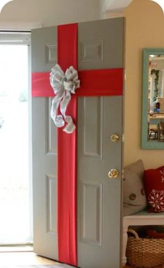 the door is decorated with red and white ribbon, bow, and decorative items on it