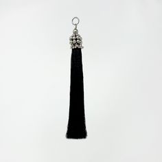 a black tassel hanging from a metal hook