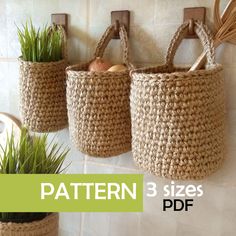 three baskets hanging on the wall with grass in them and one has an egg inside