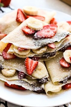 crepes with strawberries and powdered sugar are stacked on top of each other