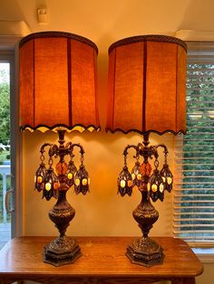 two lamps sitting on top of a wooden table