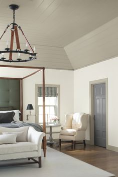 a bedroom with a bed, chair and chandelier hanging from it's ceiling