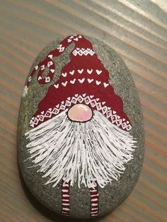 a painted rock with a gnome face on it