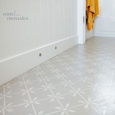 a bathroom with white walls and tile flooring next to a bathtub filled with yellow towels