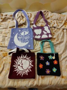 four crocheted bags sitting on top of a bed