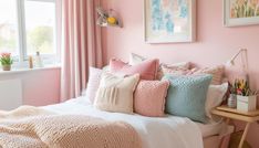 a bedroom with pink walls, white bedding and lots of pillows on the bed