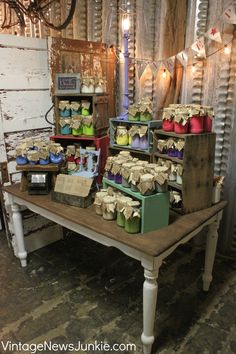 a table that has some baskets on it and candles in the middle with tags hanging from them