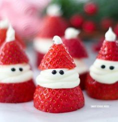 some strawberries with santa hats on them are sitting next to each other in the shape of santa claus