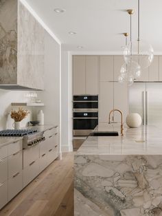 a large kitchen with marble counter tops and stainless steel appliances