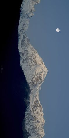 the moon shines brightly above an icy mountain