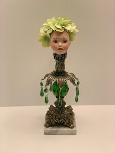 a glass figurine with flowers in her hair