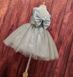 Our enchanting Knee Length flower girl dresses are sure to turn heads! This beautiful elegant sophisticated dress is handmade, the bodice consists of Silver Sequin, the back of the dress consists of an open V-back with a zipper. The big bow is detachable. The skirt consists of 4 layers of tulle with the top layer consisting with sowed in Silver pearl beads. The fifth layer is made of lining with crinoline for fullness.  This dress is perfect for any occasion!  Dress Is Pictured with a petticoat Silver Flower Girl Dress, Lace Leggings, Elegant Sophisticated, Sophisticated Dress, Solid Leggings, Silver Sequin, Birthday Dresses, Lingerie Set, Flower Dresses