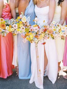 the bridesmaids are all wearing different colored dresses and holding bouquets in their hands