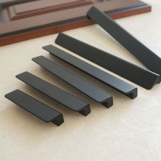 five black pieces of wood sitting on top of a table