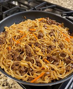 a pan filled with noodles and meat on top of a stove