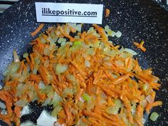 chopped carrots and onions in a frying pan with a sign that says like positive com