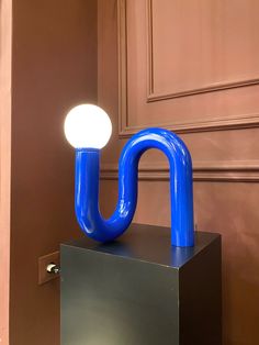 a blue object sitting on top of a metal box next to a light in a room