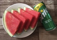 slices of watermelon on a white plate next to a can of diet coke