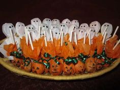 there are many pumpkins with ghost faces on them in a wicker basket that is filled with marshmallows