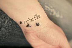 a small wrist tattoo with birds on it