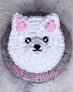 a birthday cake with a white bear face on it's frosting and pink lettering