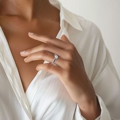 a woman wearing a white shirt and diamond ring