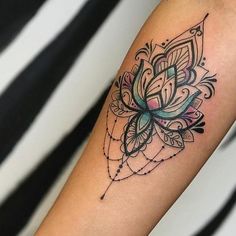 a woman's arm with a flower tattoo on the left side of her arm