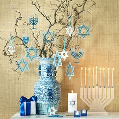 a blue and white vase sitting next to a lit menorah on a table