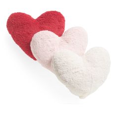 two heart shaped pillows sitting next to each other on a white surface, one red and one white