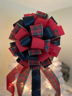 a red and blue bow on top of a christmas tree