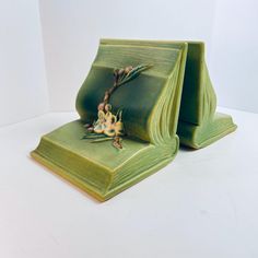 two green bookends with flowers on them sitting side by side in front of a white background