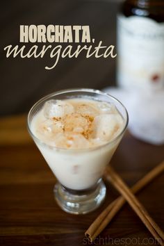 a glass filled with ice cream next to cinnamon sticks