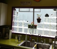 a kitchen sink sitting under a window next to a counter