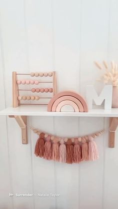 a shelf that has some items on it and is decorated with pink tassels