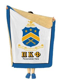 a person holding up a blanket with the coat of arms on it