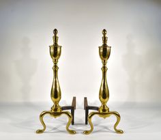 two golden candlesticks sitting next to each other