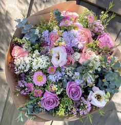 a bouquet of flowers sitting on top of a wooden table