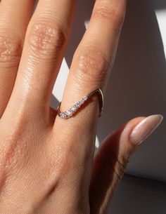 a woman's hand with a diamond ring on top of her finger and the other half of her fingers