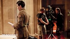 two men in uniform standing next to each other near a camera set up for filming