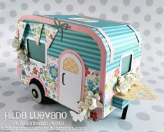 a small box shaped like a camper with flowers on it