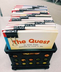 a stack of books sitting on top of a table next to each other with the words the quest written on them