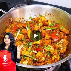 a woman standing in front of a pan filled with food