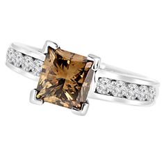 a fancy ring with an orange diamond and white diamonds on the sides, set in 18k white gold